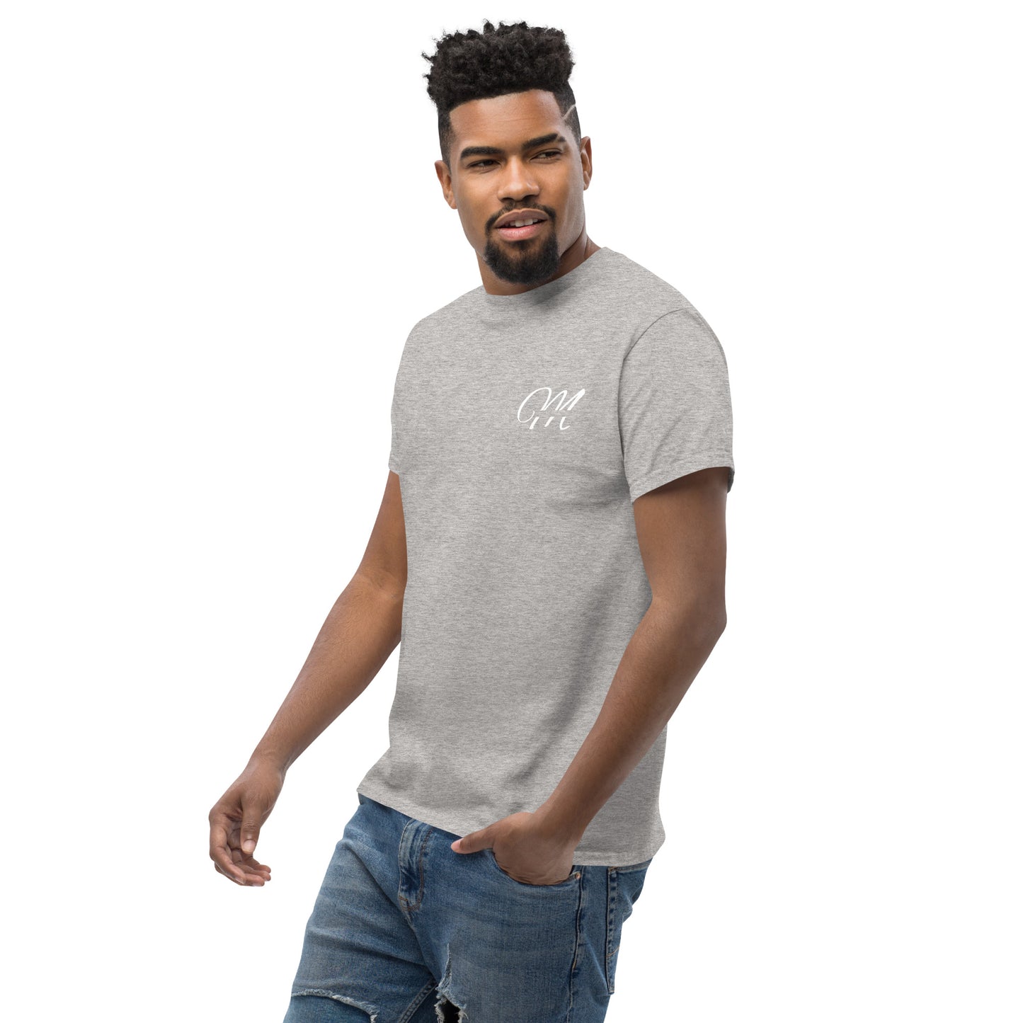 Camiseta MILLE Esencia Clásica de color gris sport con logo MILLE blanco en el pecho. Vista frontal de modelo con mano en el bolsillo.