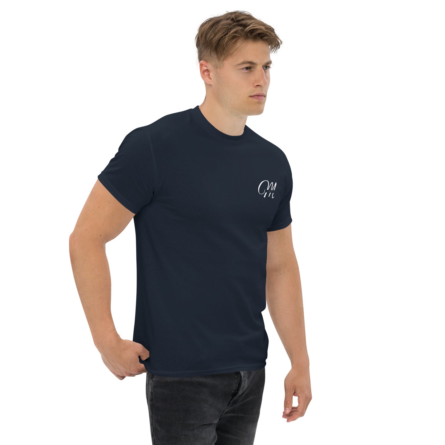Camiseta MILLE Esencia Clásica de color marino con logo MILLE blanco en el pecho. Vista frontal ligeramente lateral de modelo con mano en el bolsillo.