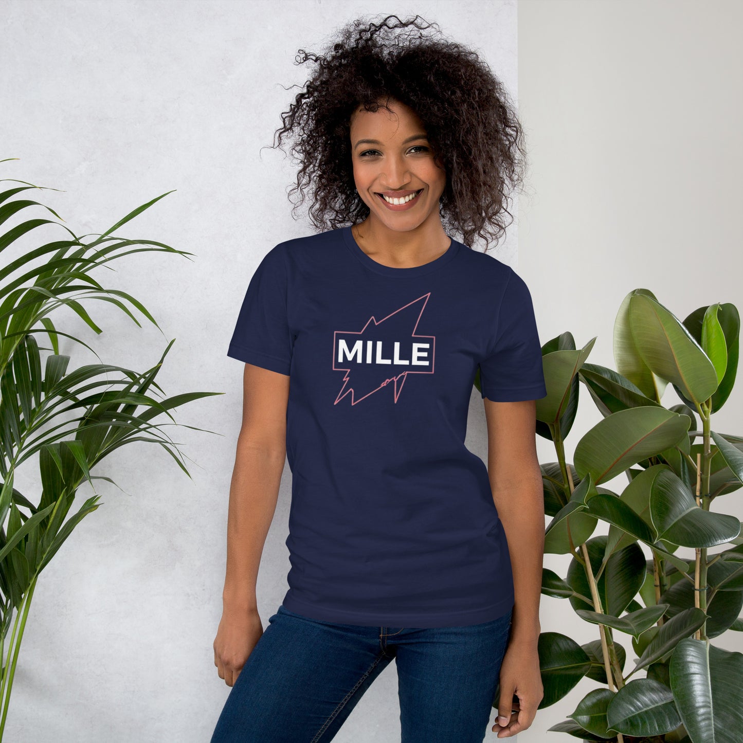 Camiseta MILLE GRIT Aura de color azul marino con logo MILLE y líneas gráficas rosadas, amarillas y azules. Vista frontal en modelo.