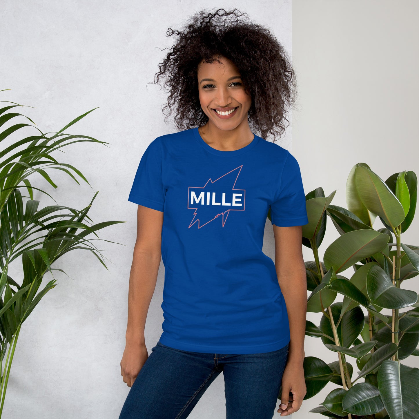 Camiseta MILLE GRIT Aura de color azul royal con logo MILLE y líneas gráficas rosadas, amarillas y azules. Vista frontal en modelo.