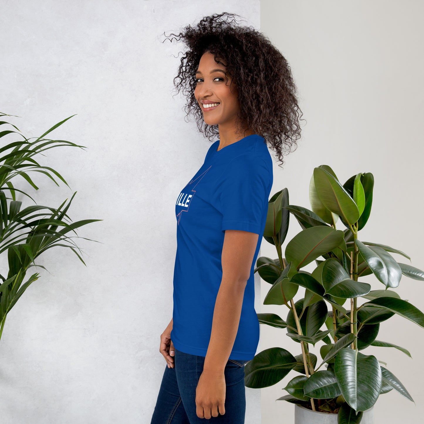 Camiseta MILLE GRIT Aura de color azul royal con logo MILLE y líneas gráficas. Vista de perfil en modelo sonriendo.