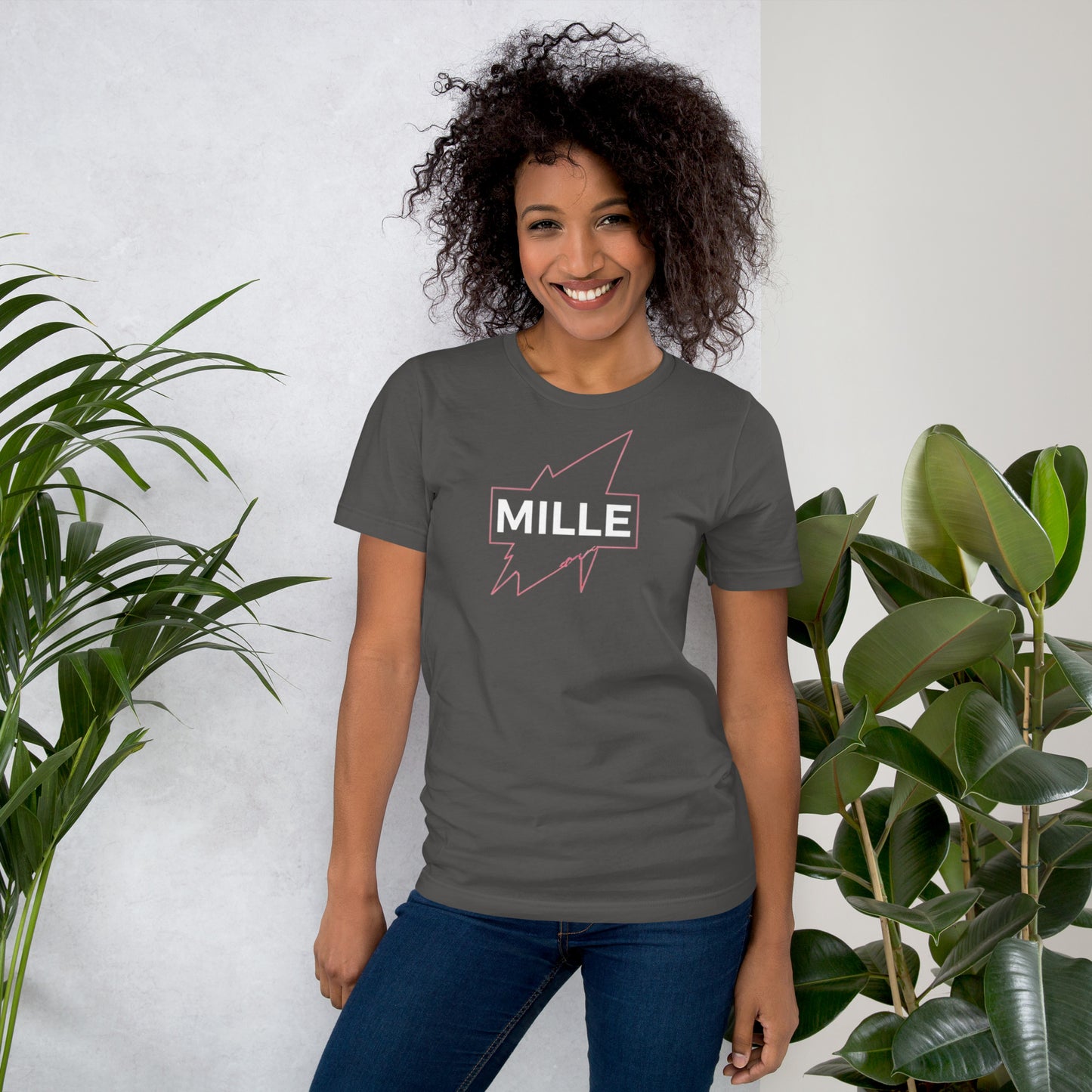 Camiseta MILLE GRIT Aura de color gris carbón (Dark Grey) con logo MILLE y líneas gráficas rosadas, amarillas y azules. Vista frontal en modelo.