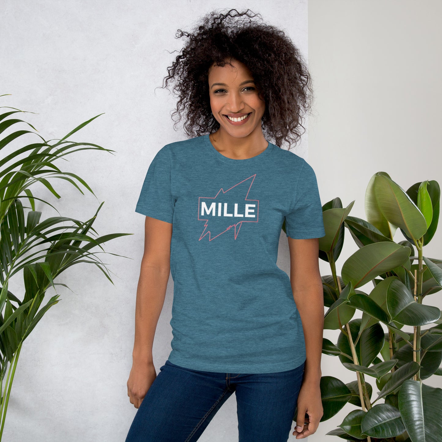 Camiseta MILLE GRIT Aura de color azul jaspeado oscuro (Heather Deep) con logo MILLE y líneas gráficas rosadas, amarillas y azules. Vista frontal en modelo.