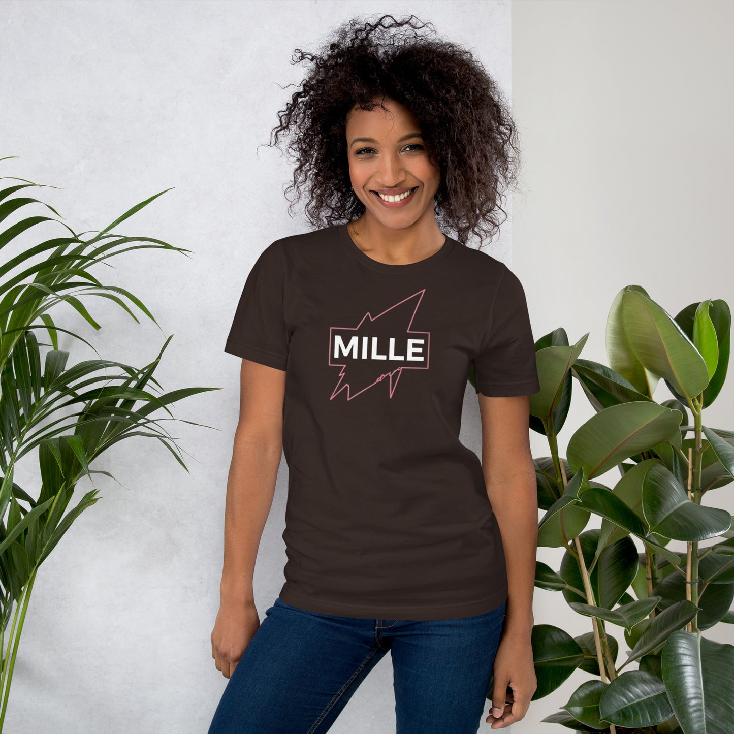 Camiseta MILLE GRIT Aura de color marrón con logo MILLE y líneas gráficas rosadas, amarillas y azules. Vista frontal en modelo.