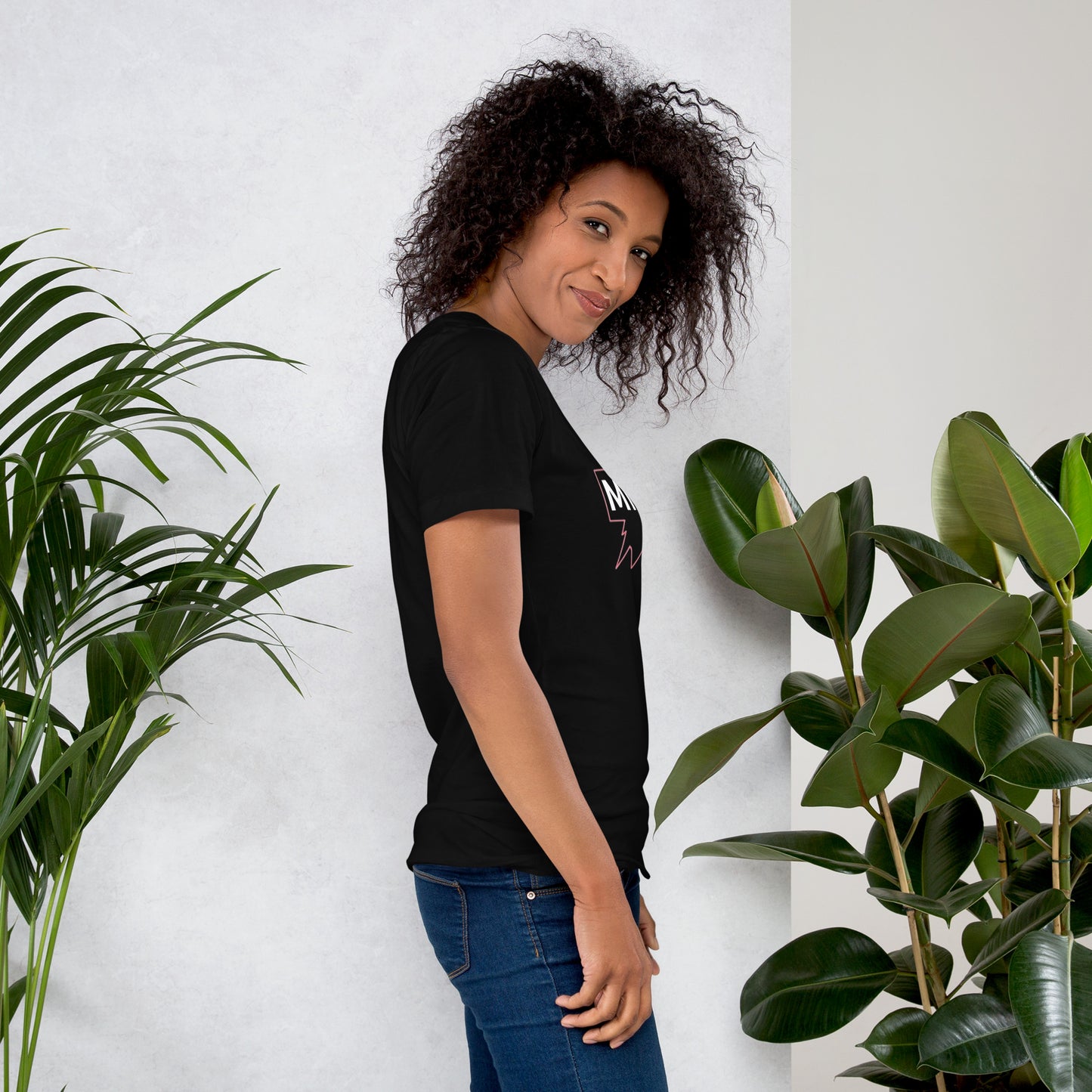 Camiseta MILLE GRIT Aura de color negro con logo MILLE y líneas gráficas. Vista de perfil en modelo.