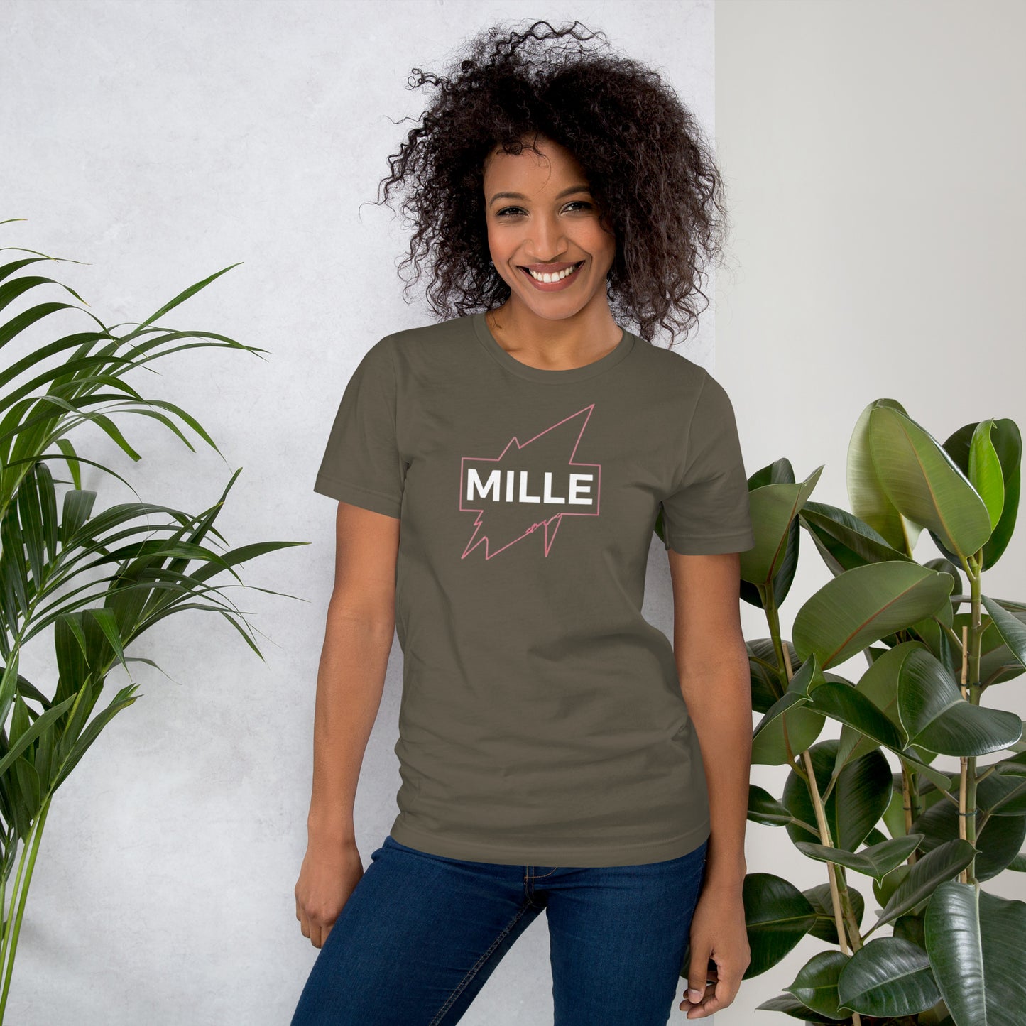 Camiseta MILLE GRIT Aura de color verde oliva (Army) con logo MILLE y líneas gráficas rosadas, amarillas y azules. Vista frontal en modelo.