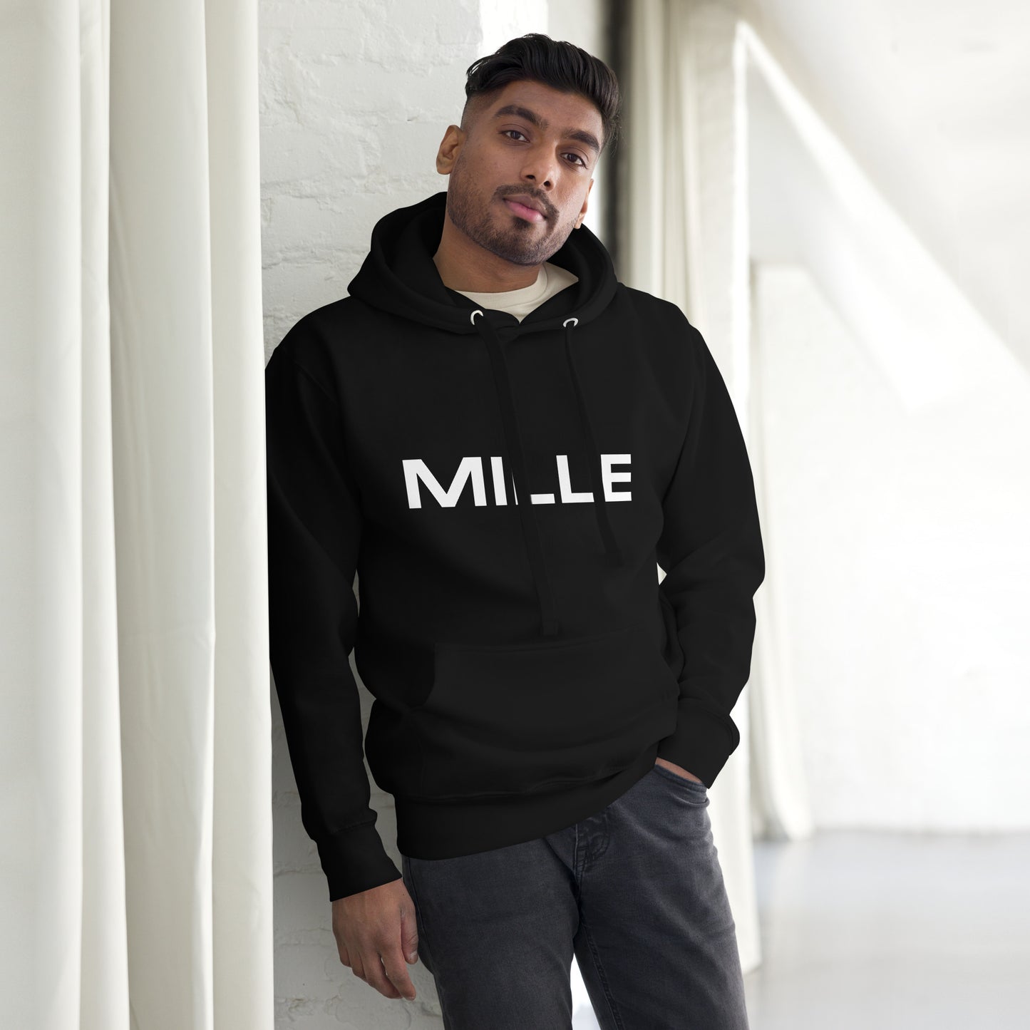 Sudadera con capucha MILLE FRECUENCIA de color negro con el logo MILLE y un círculo azul en el pecho. Vista frontal con modelo.