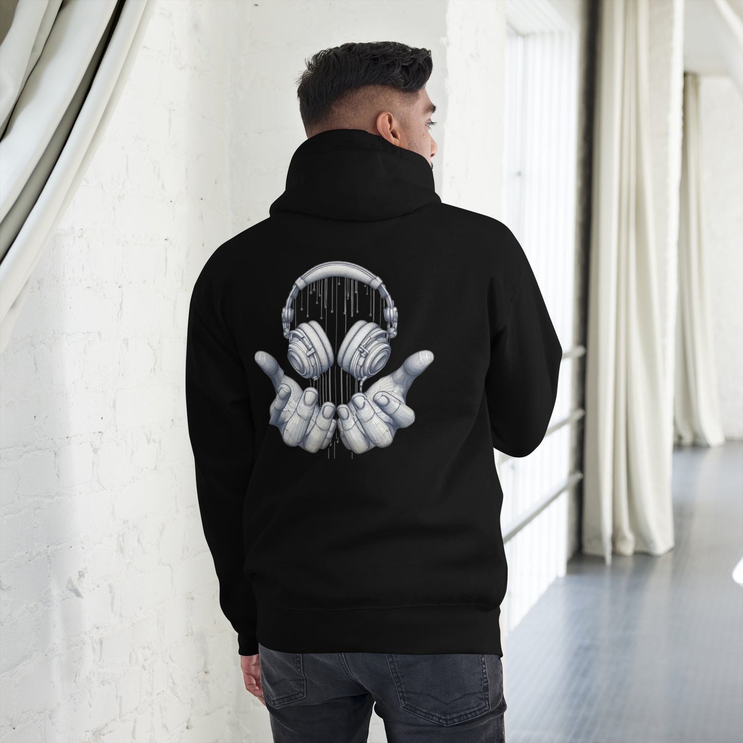 Sudadera con capucha MILLE FRECUENCIA de color negro con diseño de auriculares y manos en la espalda. Vista trasera con modelo.```