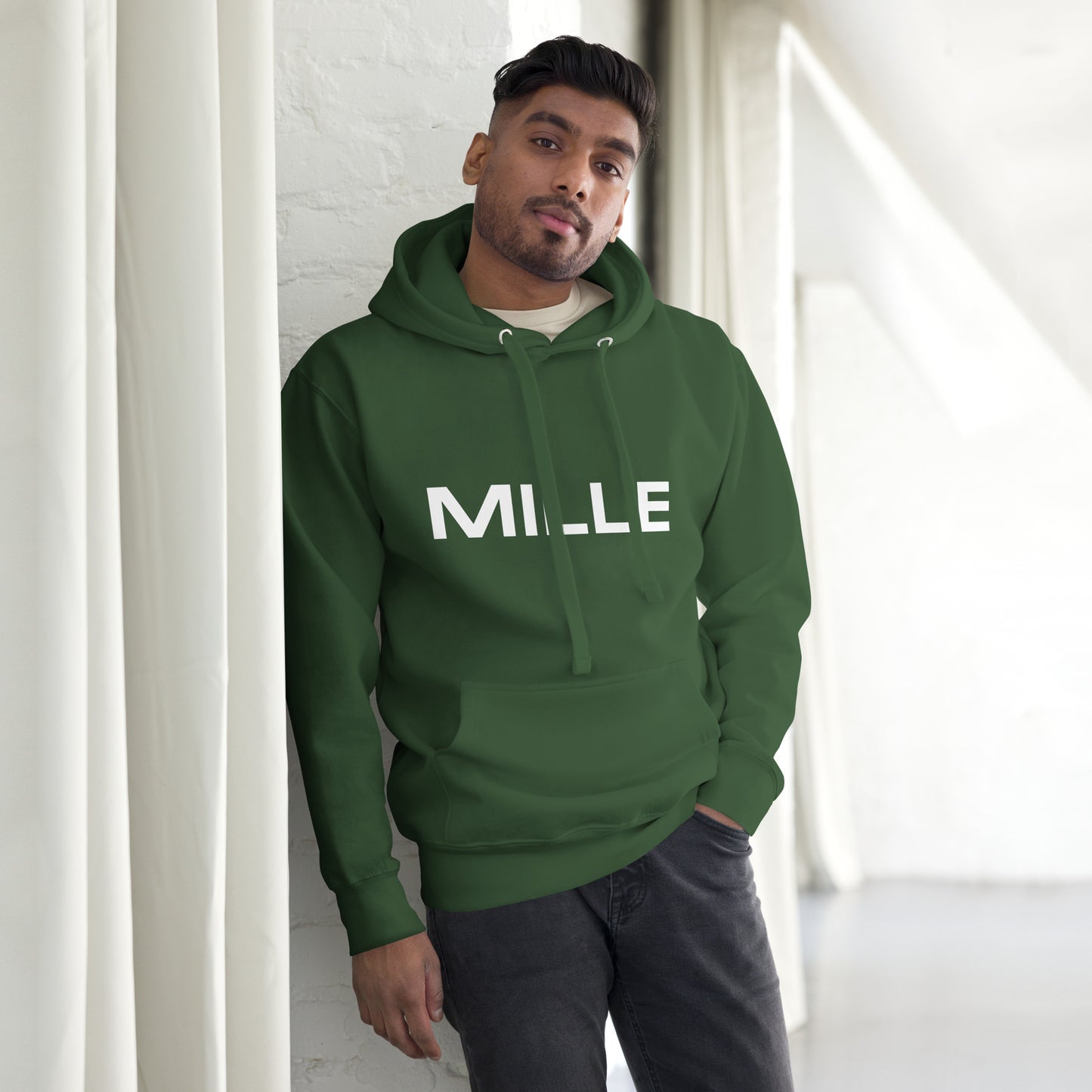 Sudadera con capucha MILLE FRECUENCIA de color verde bosque con el logo MILLE y un círculo azul en el pecho. Vista frontal con modelo.