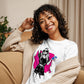 Camiseta MILLE Ink Riot de color blanco con diseño de chica urbana sobre mancha de tinta fucsia. Vista frontal con modelo sonriendo en un sofá.
