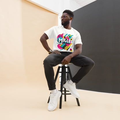 Camiseta MILLE ARCADE Tee de color blanco con diseño gráfico vibrante. Vista frontal de modelo sentado en taburete.