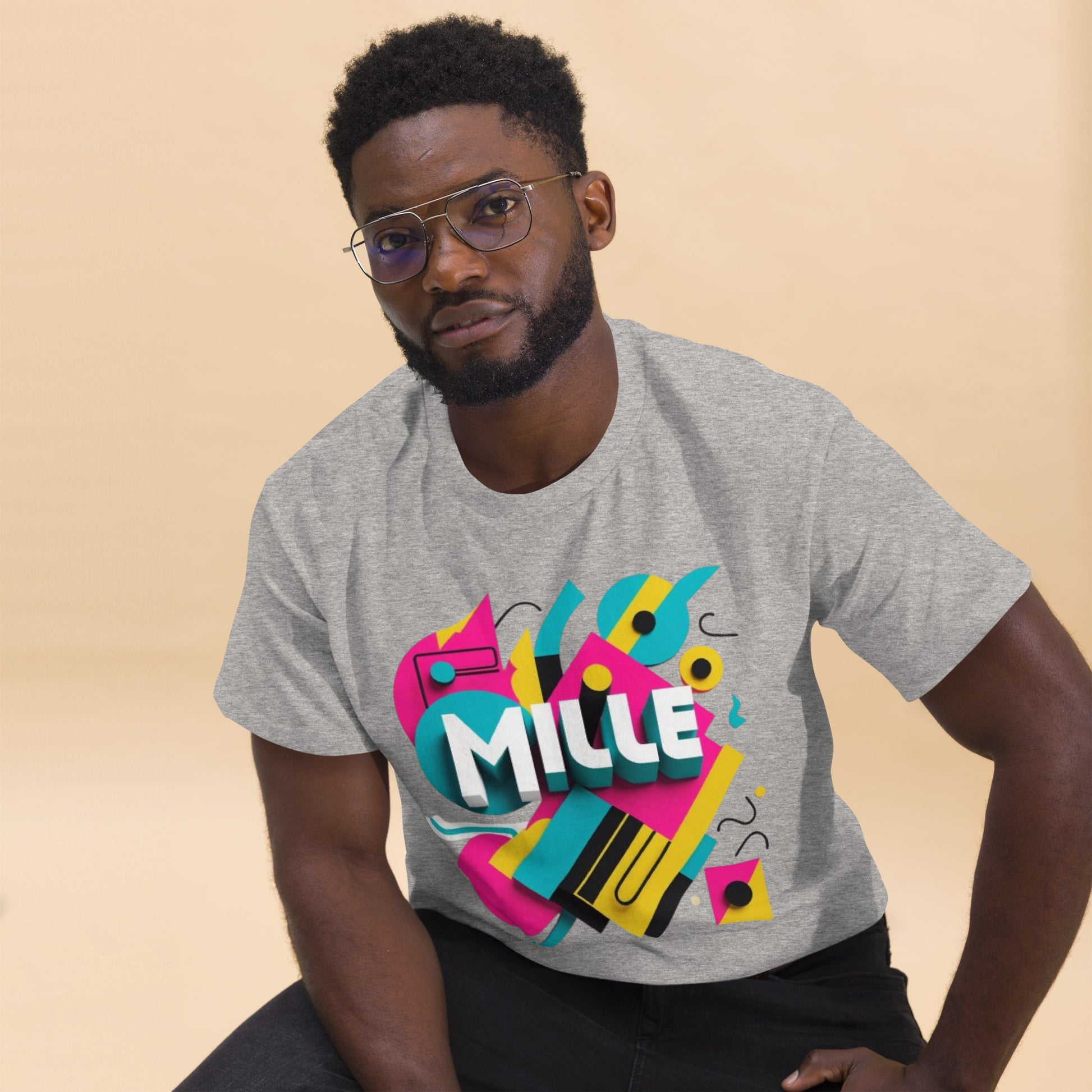 Camiseta MILLE ARCADE Tee de color gris sport con diseño gráfico vibrante. Vista frontal de modelo sentado con gafas.