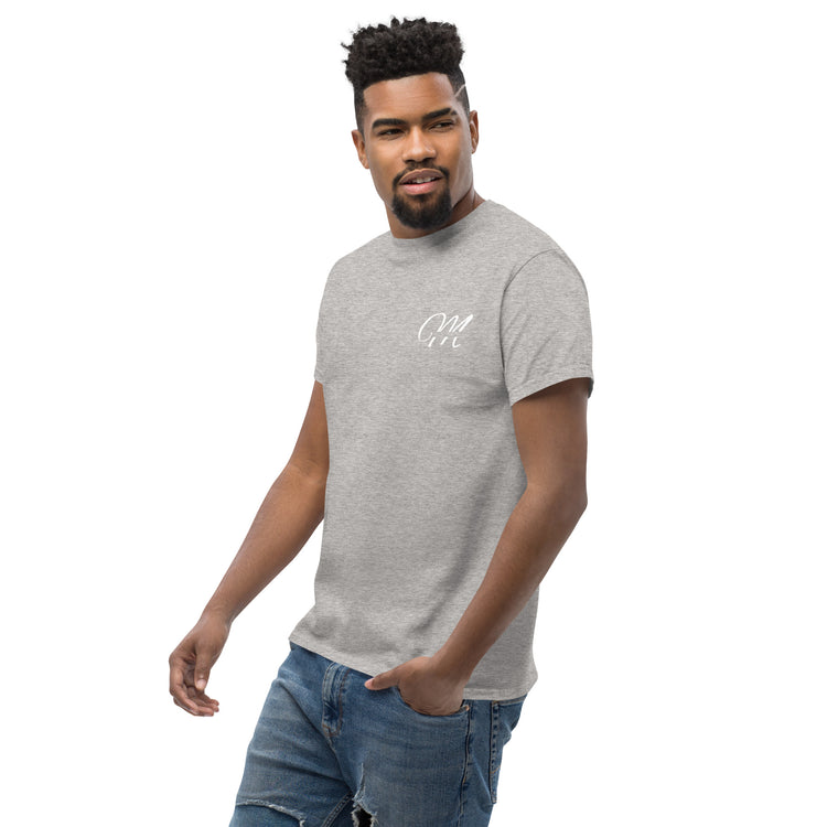 Camiseta MILLE Esencia Clásica de color gris sport con logo MILLE blanco en el pecho. Vista frontal de modelo con mano en el bolsillo.