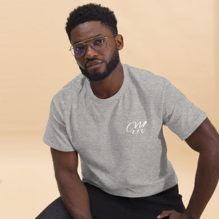 Camiseta MILLE Esencia Clásica de color gris sport con logo MILLE blanco en el pecho. Vista frontal de modelo sentado con gafas.