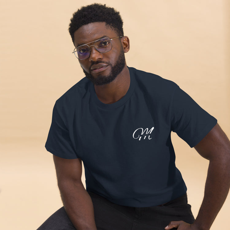 Camiseta MILLE Esencia Clásica de color marino con logo MILLE blanco en el pecho. Vista frontal de modelo sentado con gafas.