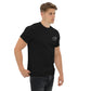 Camiseta MILLE Esencia Clásica de color negro con logo MILLE blanco en el pecho. Vista frontal ligeramente lateral de modelo con mano en el bolsillo.