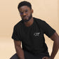 Camiseta MILLE Esencia Clásica de color negro con logo MILLE blanco en el pecho. Vista frontal de modelo sentado.