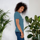 Camiseta MILLE GRIT Aura de color azul jaspeado oscuro (Heather Deep) con logo MILLE y líneas gráficas. Vista de perfil en modelo.