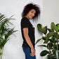 Camiseta MILLE GRIT Aura de color negro con logo MILLE y líneas gráficas. Vista de perfil en modelo.