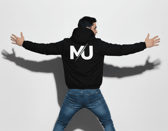 Chaqueta MILLE TEAM JACKET de color negro con logo grande en la espalda. Vista de un modelo de espaldas con los brazos extendidos.