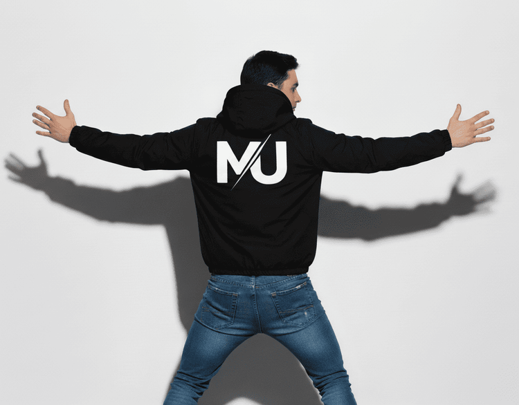 Chaqueta MILLE TEAM JACKET de color negro con logo grande en la espalda. Vista de un modelo de espaldas con los brazos extendidos.