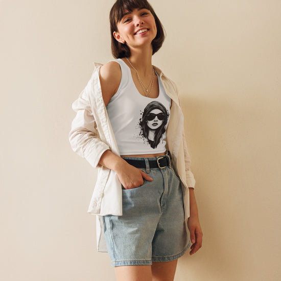 Crop top MILLE ICON de color blanco con diseño de chica con gafas en el pecho. Vista frontal con modelo sonriendo y llevando una camisa abierta.
