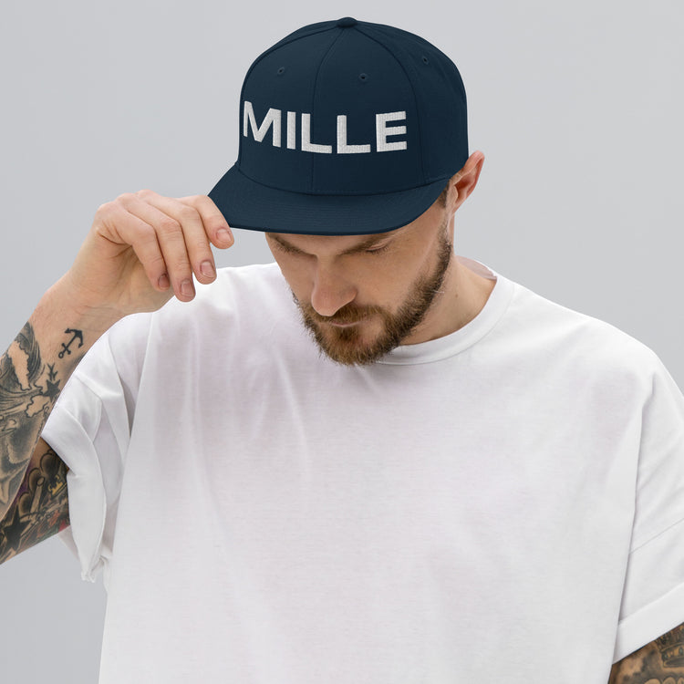 Gorra Snapback MILLE INSIGNIA de color azul marino oscuro con logo MILLE bordado en blanco. Vista frontal con modelo.