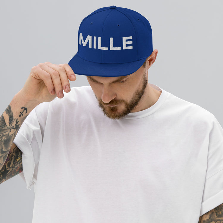 Gorra Snapback MILLE INSIGNIA de color azul royal con logo MILLE bordado en blanco. Vista frontal con modelo.