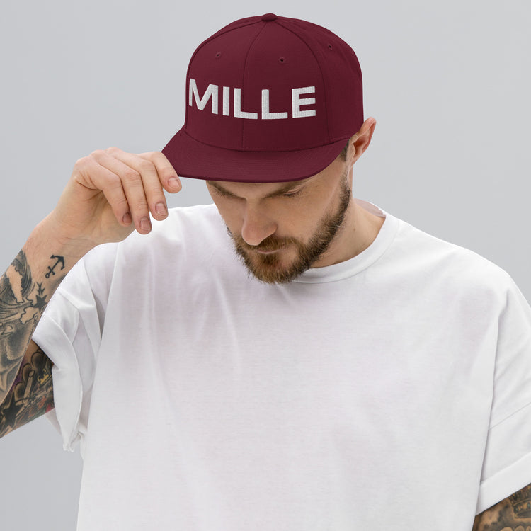 Gorra Snapback MILLE INSIGNIA de color granate con logo MILLE bordado en blanco. Vista frontal con modelo.