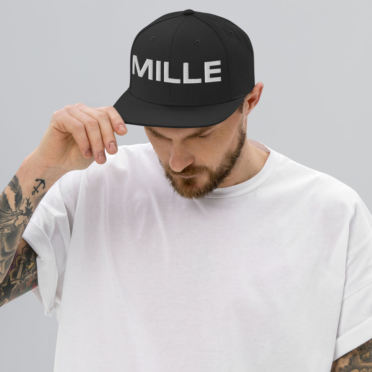 Gorra Snapback MILLE INSIGNIA de color negro con logo MILLE bordado en blanco. Vista frontal con modelo.