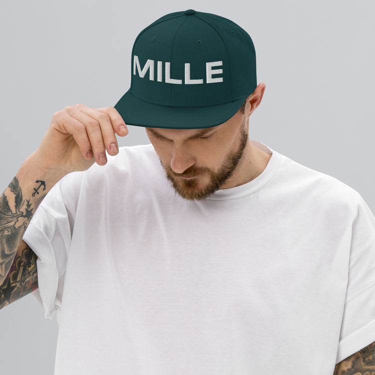 Gorra Snapback MILLE INSIGNIA de color verde spruce con logo MILLE bordado en blanco. Vista frontal con modelo.