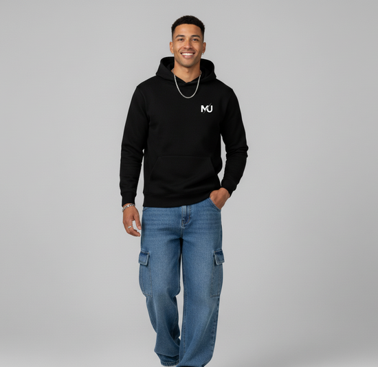 Sudadera con capucha MILLE KAIROS de color negro con logo en el pecho. Vista completa de un modelo vistiendo la sudadera con vaqueros.