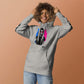Sudadera con capucha MILLE ECO de color gris carbón con diseño de artista en el pecho y logos en las mangas. Vista frontal con modelo sonriendo sobre fondo de color.
