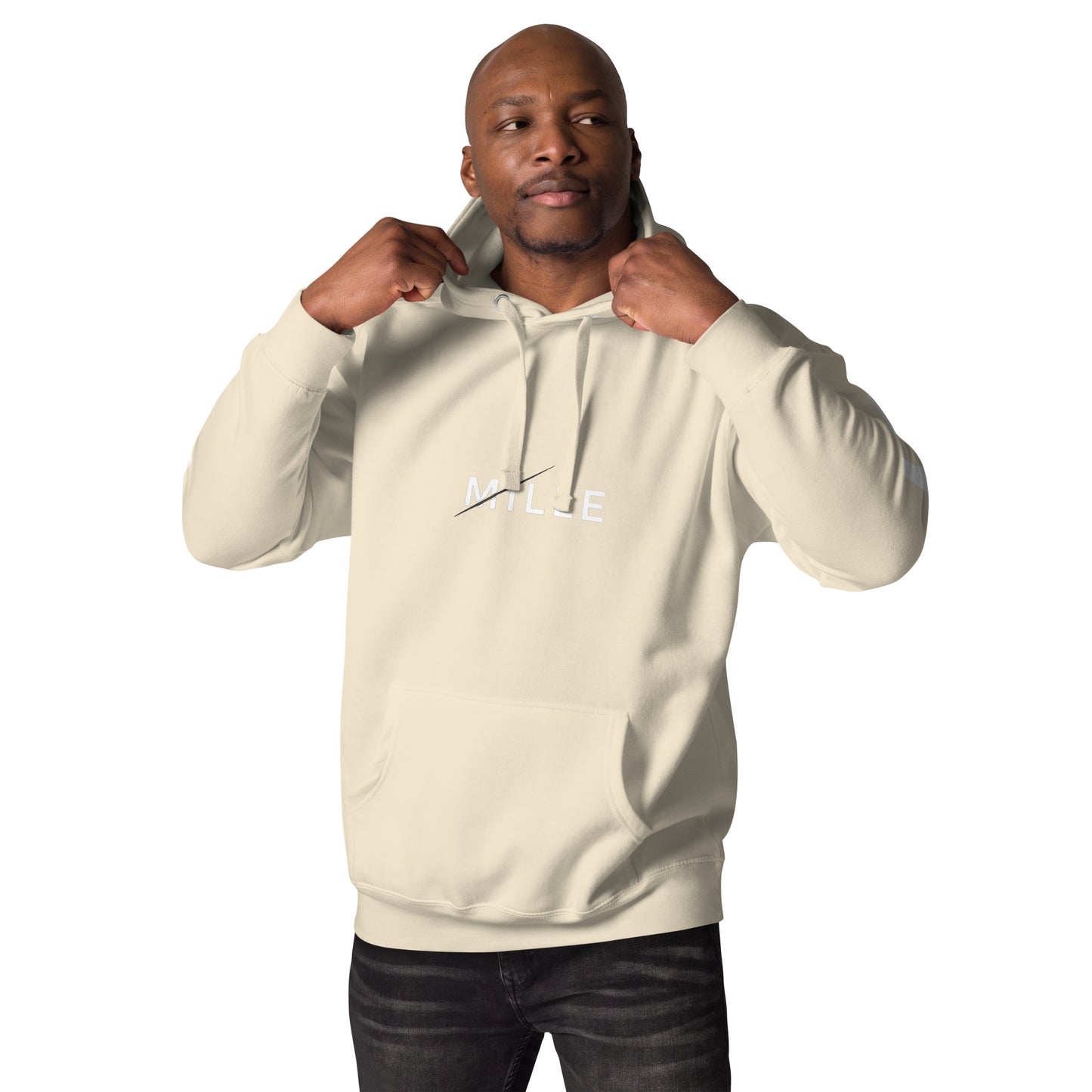 Sudadera con capucha MILLE ZENITH Hoodie de color bone con logo MILLE en el pecho. Vista frontal en modelo ajustando la capucha.