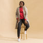 Sudadera MILLE Origin LS de color rojo con logo MILLE en el pecho. Vista de cuerpo entero con modelo sonriendo y sentada en un taburete.